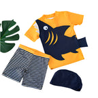 Children's shark-themed swim set with shorts and cap on a white background